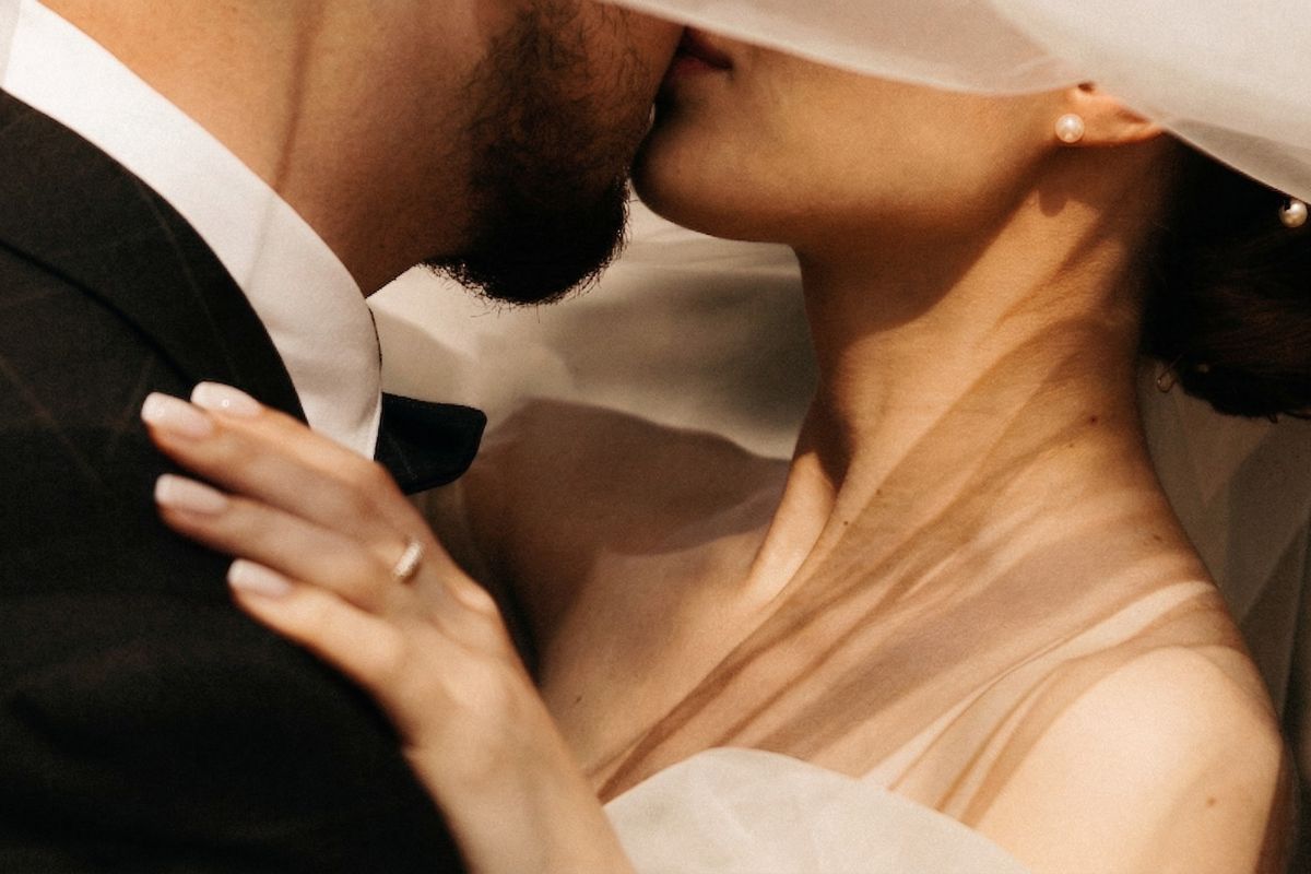 Sposi sotto il velo che si baciano, dettaglio romantico